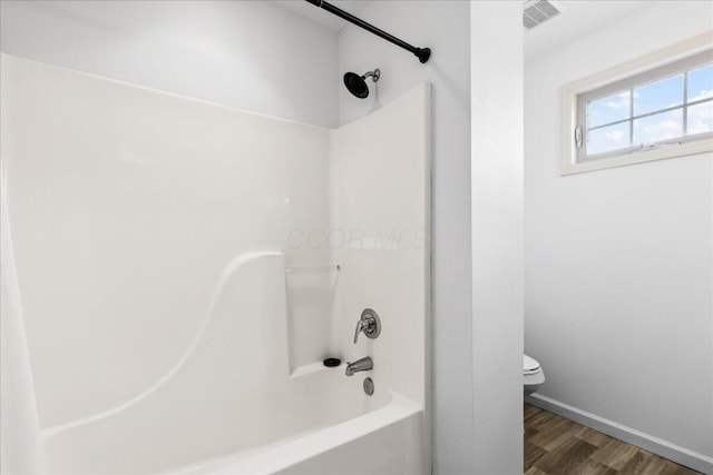 full bathroom featuring toilet, visible vents,  shower combination, and wood finished floors