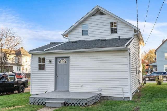 rear view of property featuring a lawn