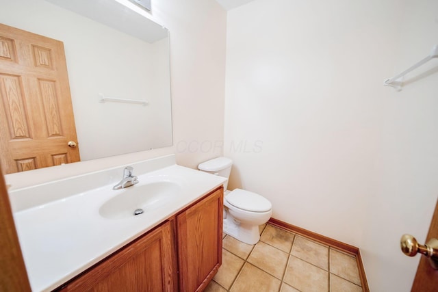 half bath featuring toilet, baseboards, vanity, and tile patterned floors