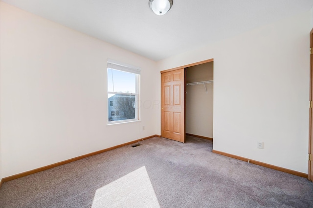 unfurnished bedroom featuring light colored carpet, a closet, visible vents, and baseboards