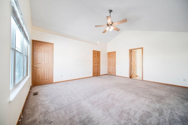 unfurnished bedroom with high vaulted ceiling, visible vents, baseboards, and multiple windows