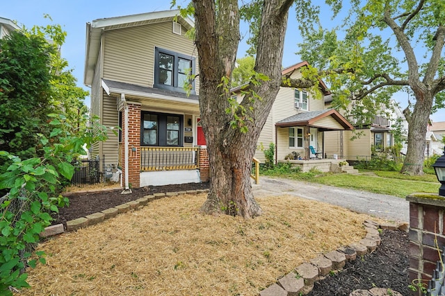 view of front of property featuring central AC, covered porch, and a front yard