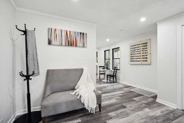 living area featuring hardwood / wood-style flooring and crown molding