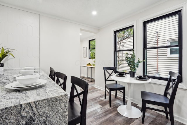 dining space with crown molding and wood-type flooring