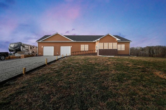 ranch-style house with a yard and a garage