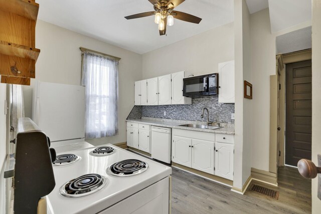 kitchen with white appliances, light countertops, a sink, and white cabinets