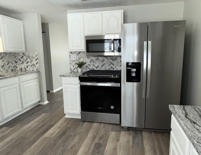 kitchen featuring dark wood-style floors, light stone counters, appliances with stainless steel finishes, and white cabinetry