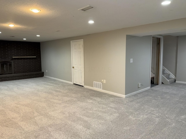 finished basement featuring light carpet, visible vents, and stairs