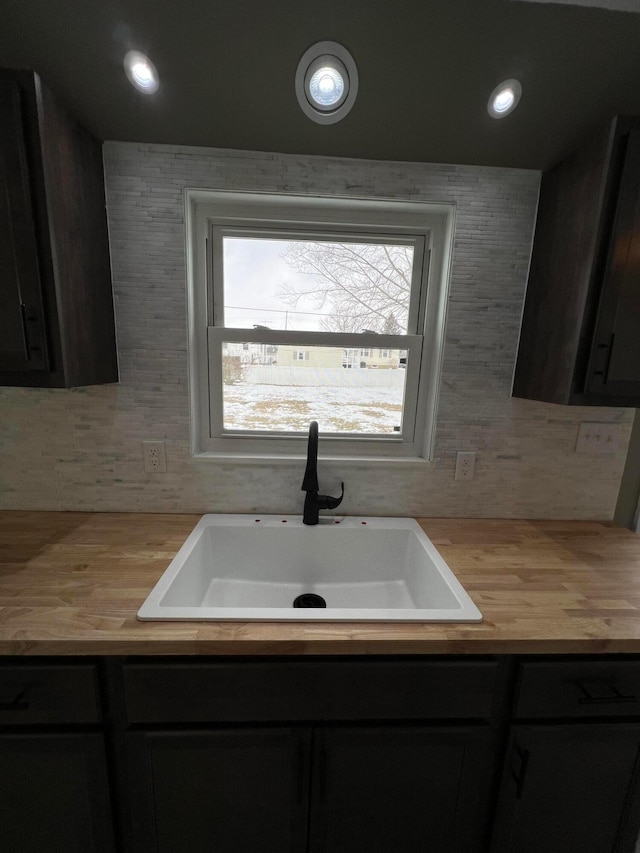 kitchen featuring recessed lighting, butcher block counters, a sink, and decorative backsplash