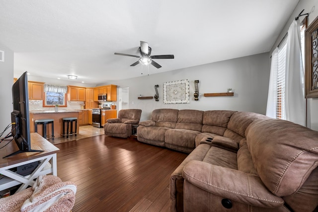 living area featuring hardwood / wood-style floors, ceiling fan, and visible vents