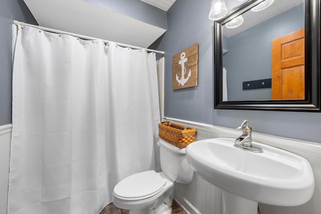 full bath featuring toilet, a sink, and curtained shower