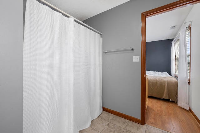 bathroom featuring baseboards, visible vents, and tile patterned flooring