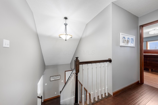 staircase featuring baseboards and wood finished floors