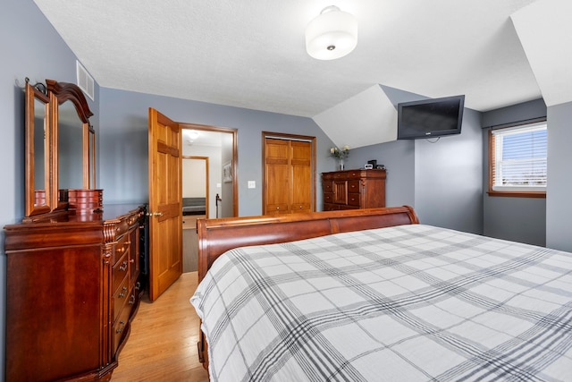 bedroom with a textured ceiling and light wood-style flooring