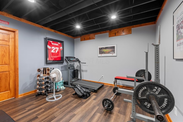 exercise room featuring baseboards and wood finished floors
