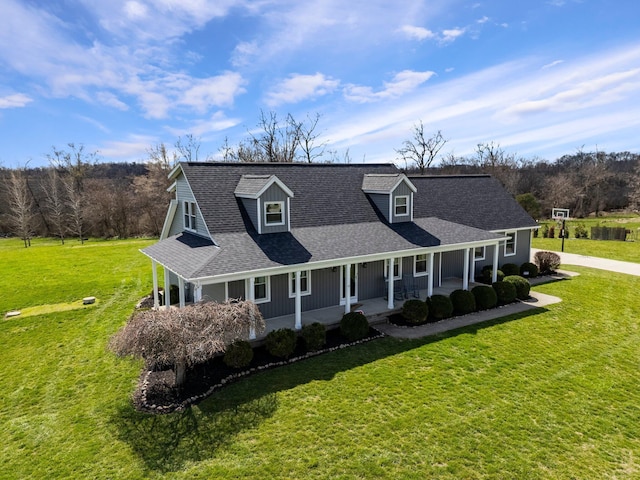 view of front of house with covered porch, a front yard, and roof with shingles
