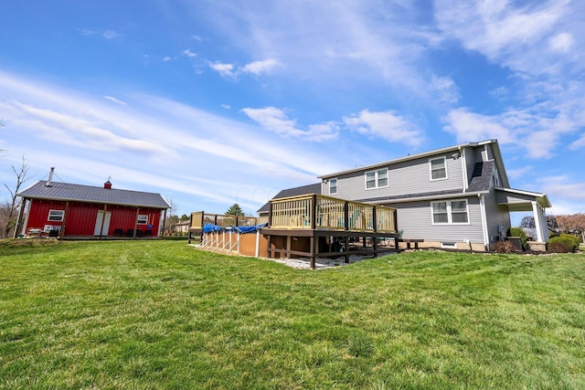 back of property featuring a lawn and a deck
