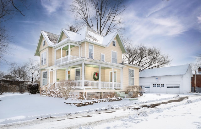 victorian-style house featuring covered porch and a garage