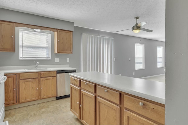 kitchen featuring dishwasher, ceiling fan, light countertops, a textured ceiling, and a sink