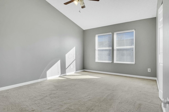 spare room with lofted ceiling, light colored carpet, and baseboards