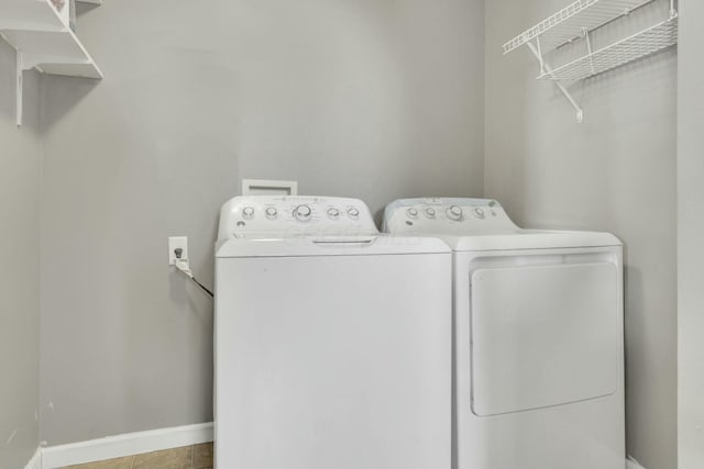 washroom featuring laundry area, washer and clothes dryer, and baseboards