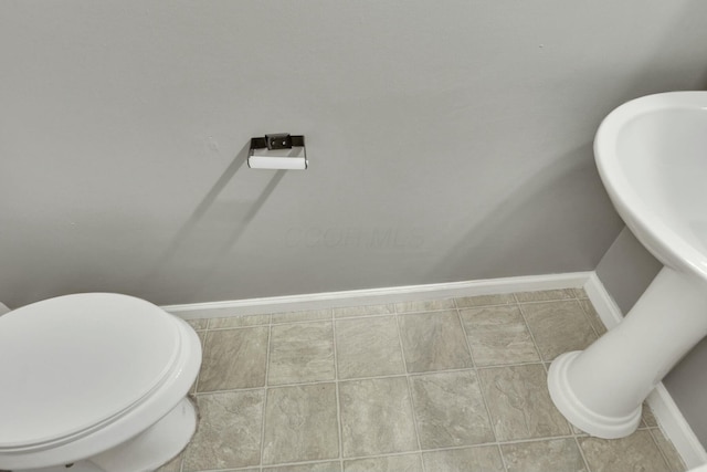 bathroom featuring tile patterned flooring, toilet, and baseboards