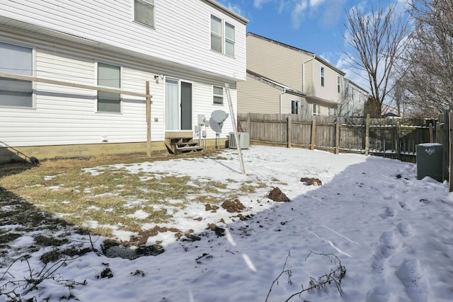 snow covered house with entry steps and fence