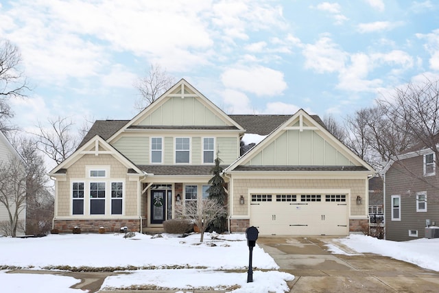 craftsman inspired home with board and batten siding, stone siding, driveway, and a garage