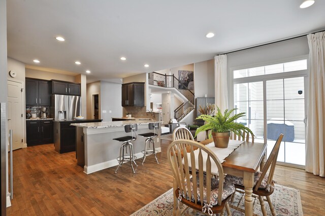 dining area with stairs, wood finished floors, and recessed lighting