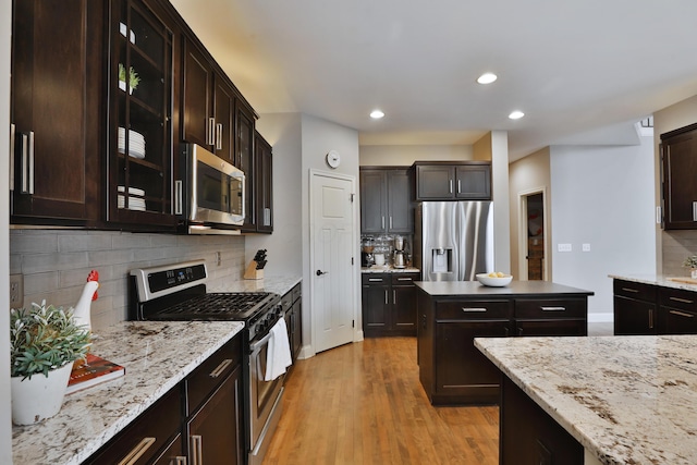 kitchen featuring dark brown cabinetry, light wood-style flooring, recessed lighting, appliances with stainless steel finishes, and tasteful backsplash