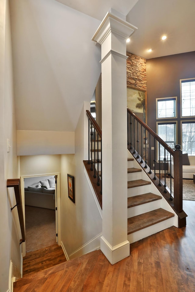 stairs with baseboards, recessed lighting, wood-type flooring, and ornate columns