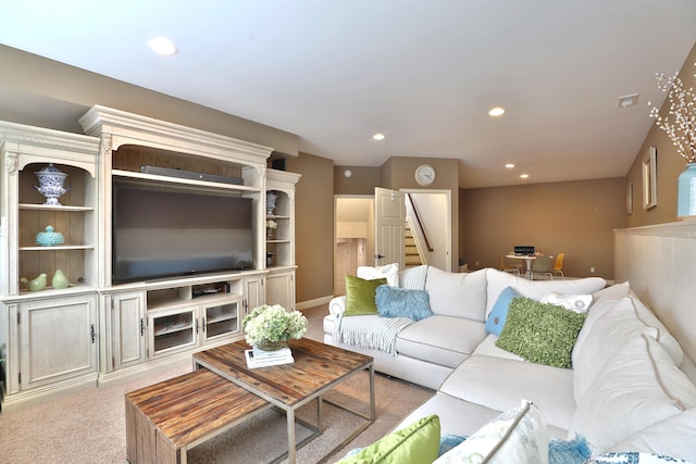 living room featuring recessed lighting, visible vents, stairway, and light colored carpet