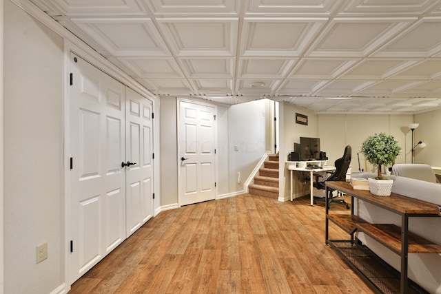 interior space with an ornate ceiling, light wood-style flooring, and baseboards