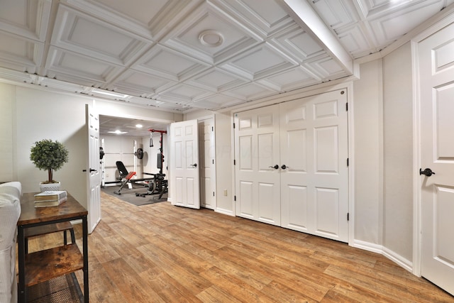 finished basement featuring light wood-style floors, an ornate ceiling, and baseboards