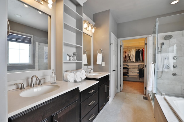 bathroom featuring a walk in closet, a shower stall, vanity, and a bathing tub