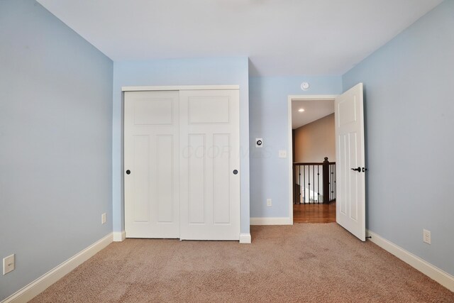 unfurnished bedroom with carpet floors, a closet, and baseboards