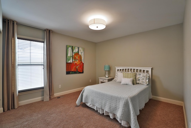 carpeted bedroom with visible vents and baseboards