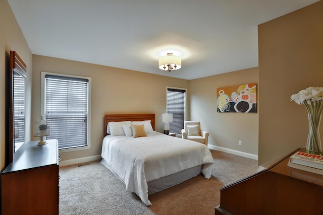 carpeted bedroom with visible vents and baseboards