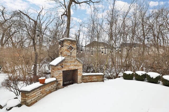 snowy yard featuring a fireplace