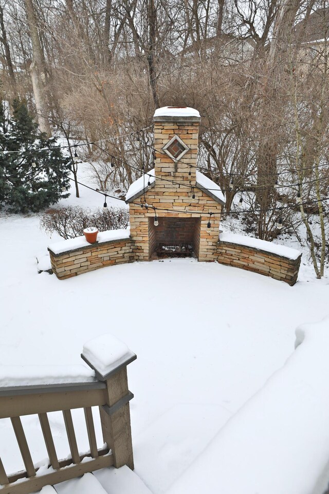 yard covered in snow featuring a stone fireplace