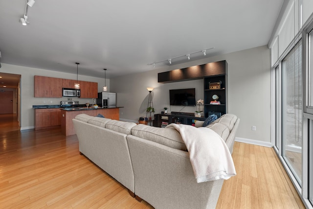 living area featuring light wood-style flooring and baseboards