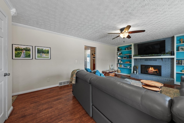 living room featuring dark wood-style floors, a fireplace, visible vents, ceiling fan, and a textured ceiling