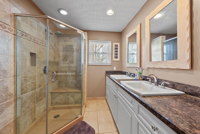 full bath featuring a stall shower, tile patterned flooring, and a sink