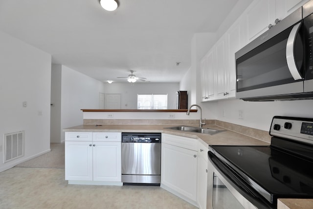 kitchen with stainless steel appliances, light countertops, visible vents, white cabinetry, and a sink