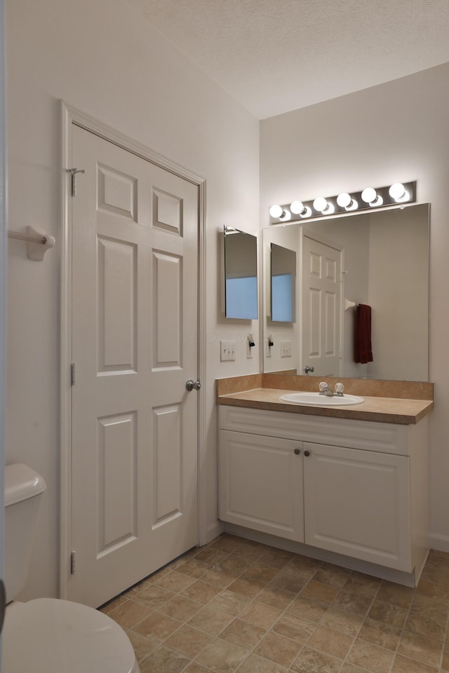 half bathroom with vanity and toilet