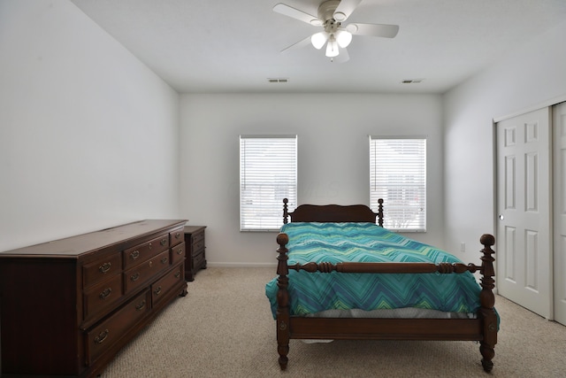 bedroom with light carpet, multiple windows, a closet, and visible vents