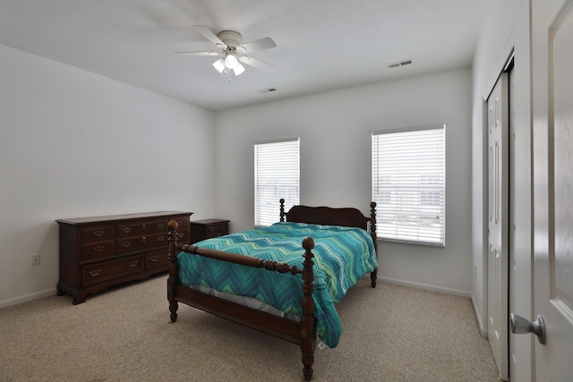 bedroom featuring baseboards, visible vents, and light colored carpet