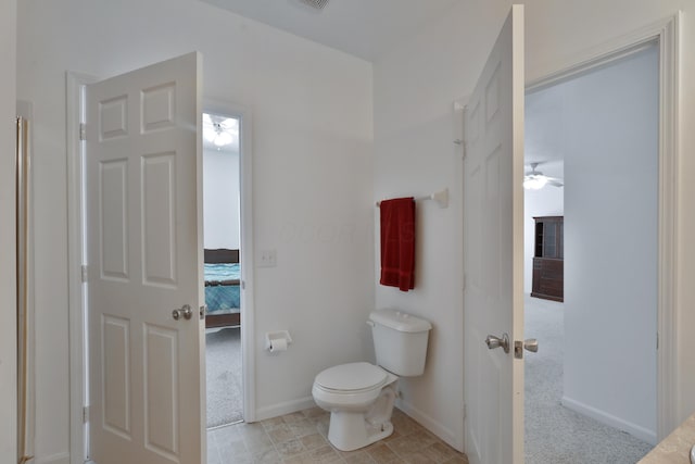 ensuite bathroom with toilet, baseboards, a ceiling fan, and ensuite bathroom