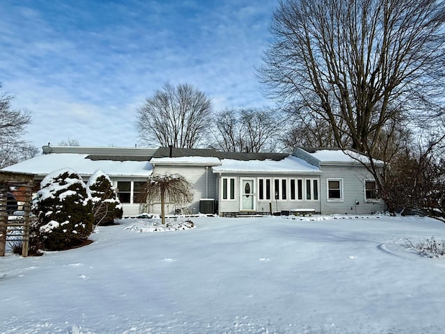 view of front facade featuring an attached garage, a sunroom, and cooling unit