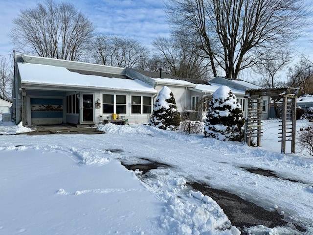 view of front of home with a garage and a sunroom